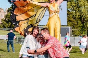 Guests with butterfly stilt walkers at Classic Ibiza Burghley 2023