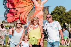 Guests with butterfly stilt walkers at Classic Ibiza Burghley 2023