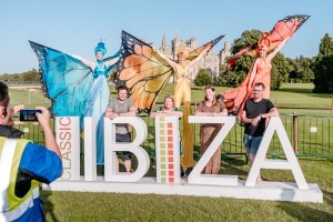 Guests with butterfly stilt walkers at Classic Ibiza Burghley 2023