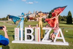 Guests with butterfly stilt walkers at Classic Ibiza Burghley 2023