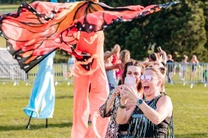 Guests with butterfly stilt walkers at Classic Ibiza Burghley 2023