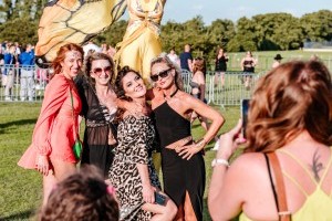 Guests with butterfly stilt walkers at Classic Ibiza Burghley 2023