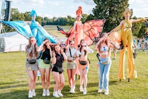 Guests with butterfly stilt walkers at Classic Ibiza Burghley 2023